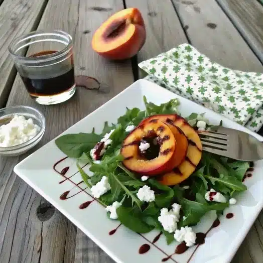 Grilled peach salad with arugula, goat cheese, and balsamic glaze.